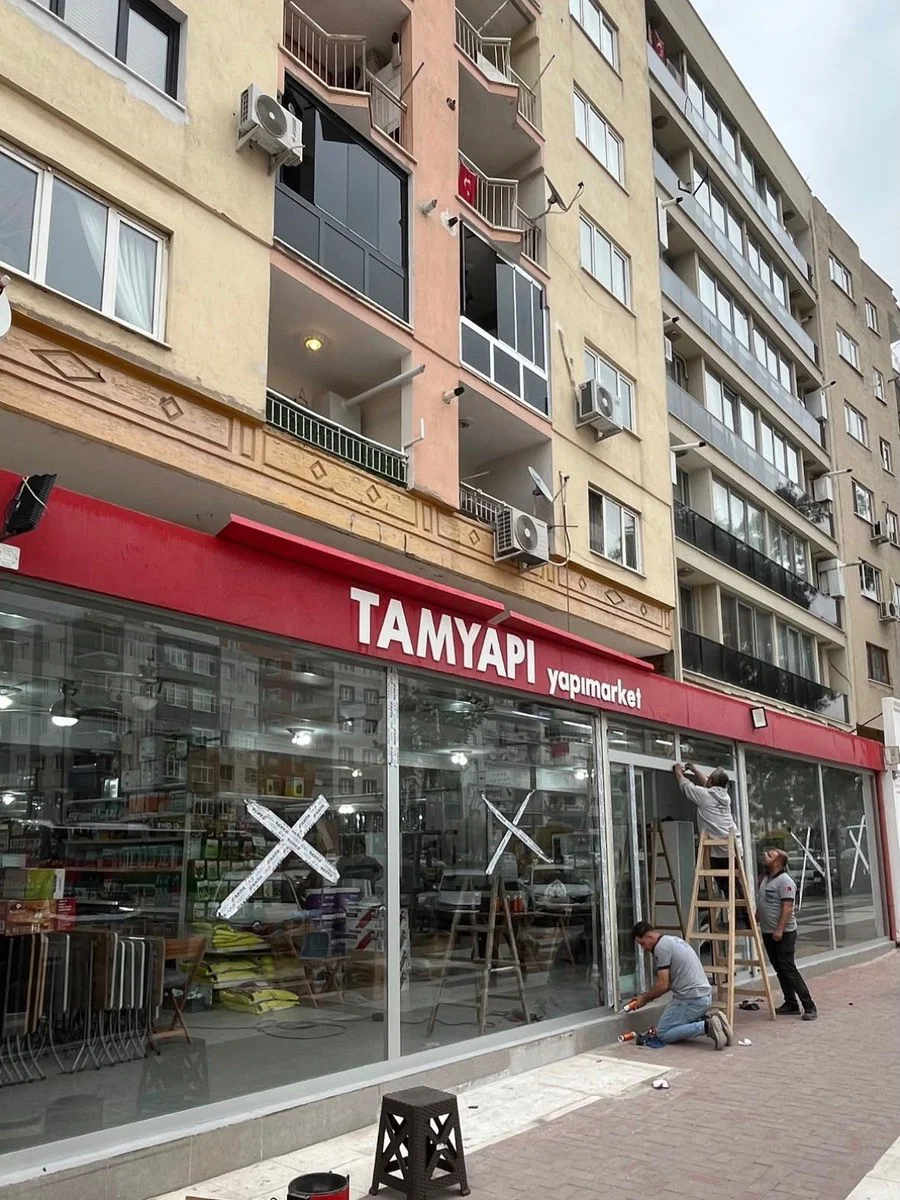 Akhisar'da mağaza vitrini cam montajı — Erten Cam ekibi